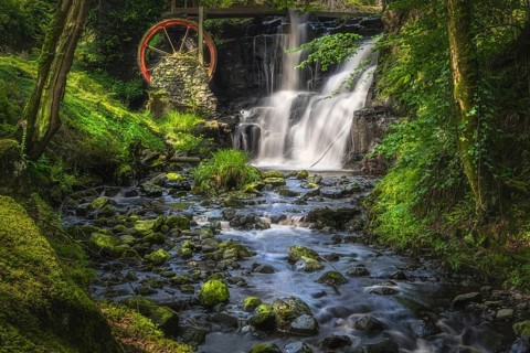 Stream leading to red waterwheel and waterfall in Glenariff Forest Park, County Antrim, Northern