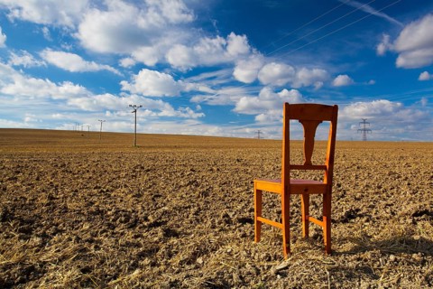 Old wooden chair on the empty field after harvest