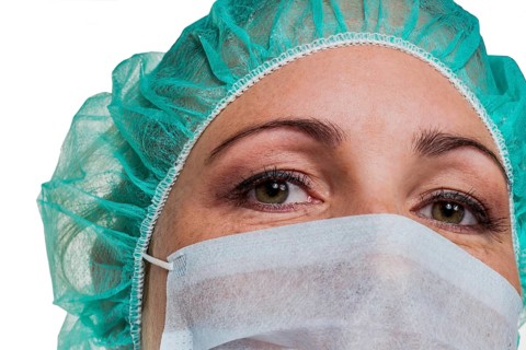 A nurse or doctor in surgical clothing in front of an operation. Symbolic photo for stress and