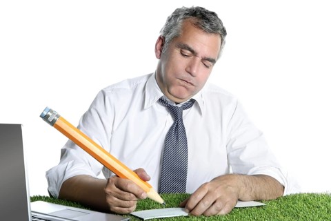 Businessman senior sign bank check funny humor gesture big pencil on green grass