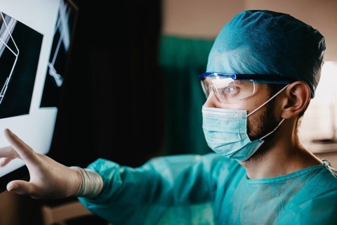 Medical professional scrutinizing x-ray with measured focus