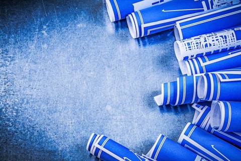 Composition of blue rolled construction drawings on metallic background maintenance concept