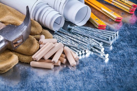Construction drawings hammer safety gloves wooden meter metal nails and dowels on scratched