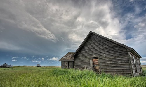 Abandoned Farm with storm clouds in the Canadian Prairie