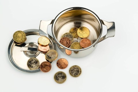 A cooking pot with a few euro coins, a symbolic photo of sovereign debt and the financial crisis in