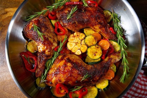 Roasted chicken legs with various vegetables and spices