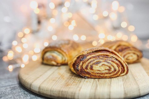 Cinnamon pastries on a wooden board with soft glowing lights