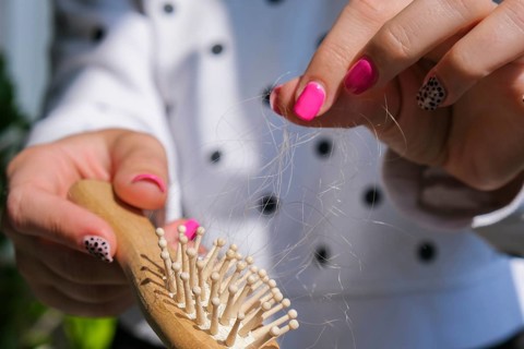 Hair loss on the comb, massage wooden brush with a clump of hair, problem of growth, hair care