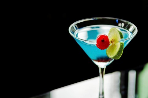 Blue curacao cocktail with cherry and lime