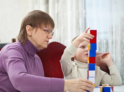 Granny is playing blocks with her grandson at home, Belgium, Europe