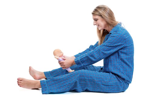 A young Beautiful Woman playing with a baby doll
