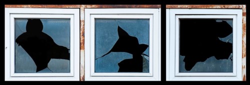 Broken windows of old building. White frames