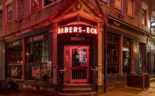The façade of a traditional Hamburg pub with glowing red neon lights at night, Hans-Albers-Eck, St.