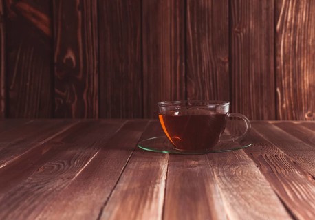 Glass cup of tea on a wooden table