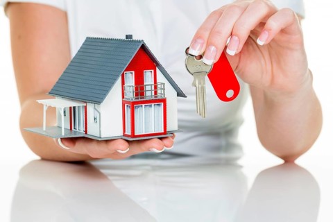 A real estate agent for properties with a house and a key Successful letting and house sales by