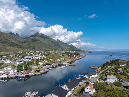 Village scene amidst lush landscape, in the background view of the Vestfjord, Sorvagen, Lofoten,