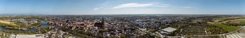 Panoramic view of a large city with river (Danube), red roofs and extensive landscape under a blue