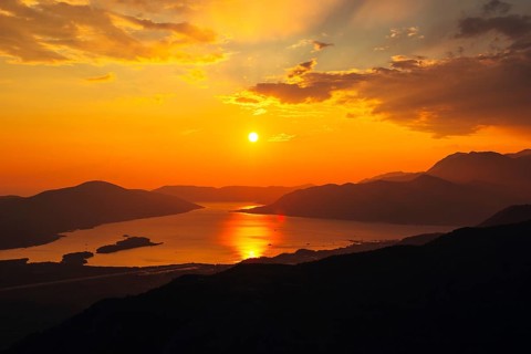 Sunset in Montenegro over the mountains and the sea. Orange sunsets