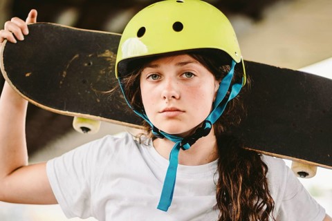 Schoolgirl after lessons at skateboarding practice in outdoor skate park. Stylish and beautiful