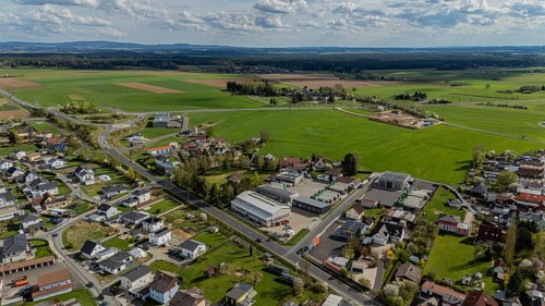 Aerial view of a village with houses, streets and fields under a slightly cloudy sky, Mitterteich,
