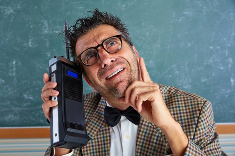 Nerd silly private investigator with retro walkie talkie on teacher balckboard