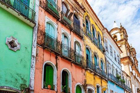 Facades of colorful houses and church in baroque and colonial style damaged by time in the