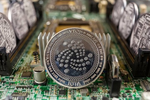 IOTA coin close-up on a computer circuit motherboard as a blockchain technology payment network.