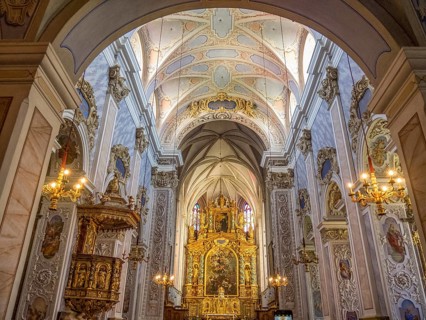 Magnificent interior of a baroque-style church with richly decorated altar and ceiling paintings