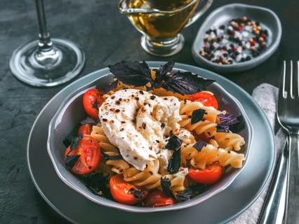 Tasty italian fusilli pasta with cherry, mozarella or buratta cheese and fresh basil. Dish with