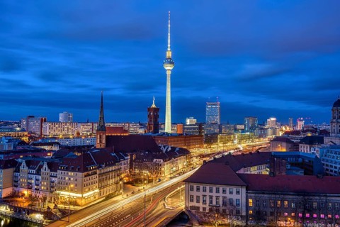 The centre of Berlin with the famous television tower and a cloudy sky at night