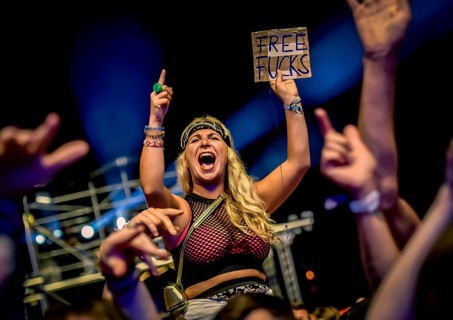 A female festival visitor with a sign at the Trailerpark concert with the inscription Free Fucks