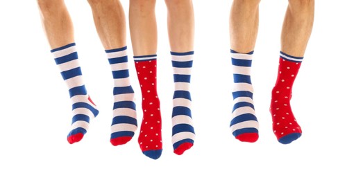 Feet in striped and dotted socks isolated over white background
