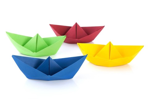 Colorful folded paper boats isolated over white background