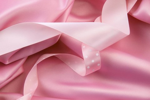 Pink satin silk background with colored ribbons