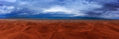 Aerial panorama view on sand dunes with storm clouds at sunset in Gobi Desert, Mongolia, Asia