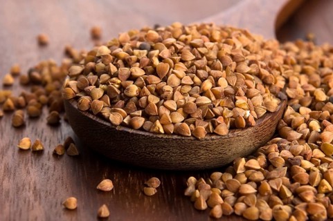 Buckwheat seeds on wooden spoon in closeup, lodz, poland
