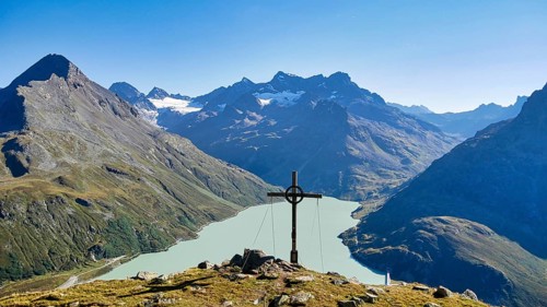 Summit cross on the Bielerkof with views of the Silvretta reservoir, Hohes Rad, Piz Buin and other