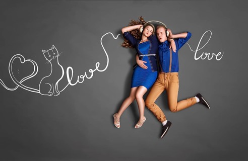 Happy valentines love story concept of a romantic couple sharing headphones and listening to music