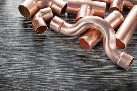 Plumbing copper water pipe fittings on wooden board