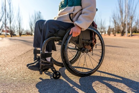 Person using wheelchair enjoying a sunny day in a park, promoting inclusion and accessibility for