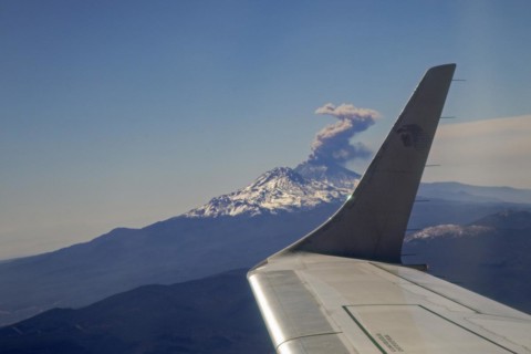 Mexico City, An AeroMexico jet flies past the erupting Popocatepetl volcano