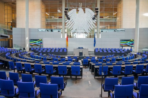 The plenary chamber of the Bundestag with many blue seats and the German flag, Reichstag building,