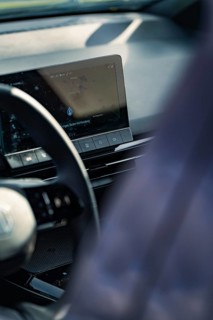 Detailed view of a modern car interior with steering wheel and display on the dashboard, e-car