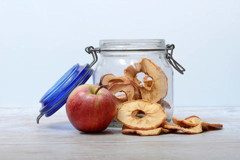 Apple and dried apple rings in glass containers, dried fruit