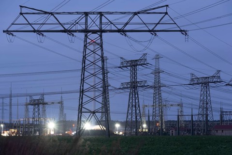 High-voltage pylons illuminated at dusk, industrial environment, quiet atmosphere, Wolmirstedt,