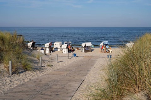Path made of wooden boards between the dunes, beach chairs on the sandy beach, Loddin, Usedom