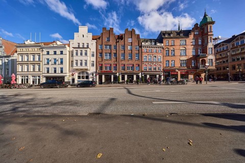 Row of historic buildings, brick buildings, gables, blue sky with cumulus clouds, street An der