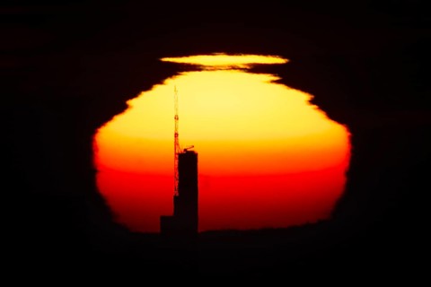 The top of the Commerzbank Tower in Frankfurt am Main stands out against the rising sun, Frankfurt