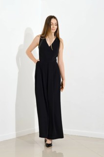 Cute lovely young woman in long sleeveless dress walking in bright room
