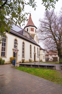Old church surrounded by trees, well-kept pavement in the foreground, quiet atmosphere,
